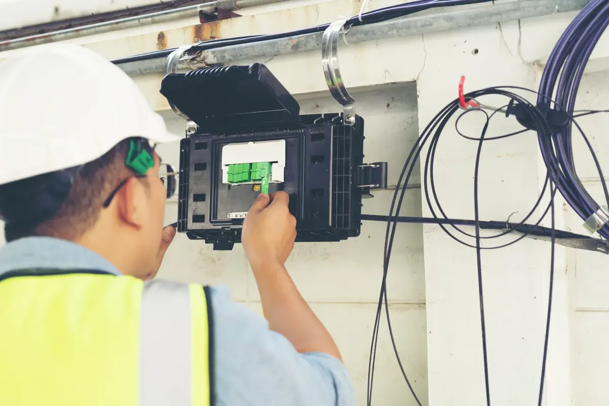 Engineer connecting a full fibre line at a wall box