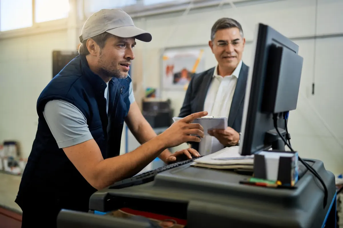 IT engineer helping staff at a computer