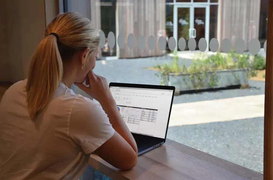 Café owner checking sales on a laptop